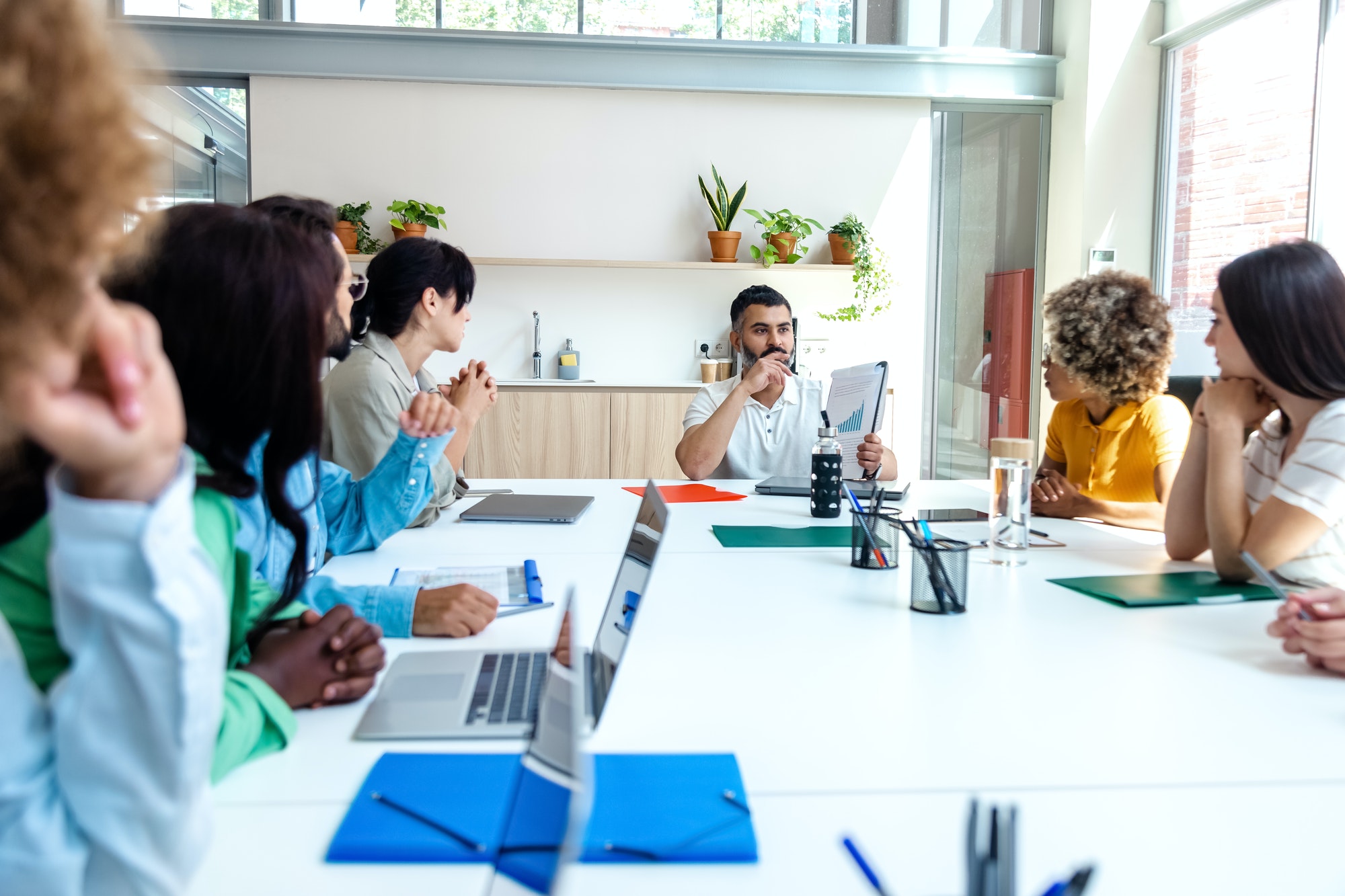 Multiracial employees listen to indian boss in company meeting. Copy space.