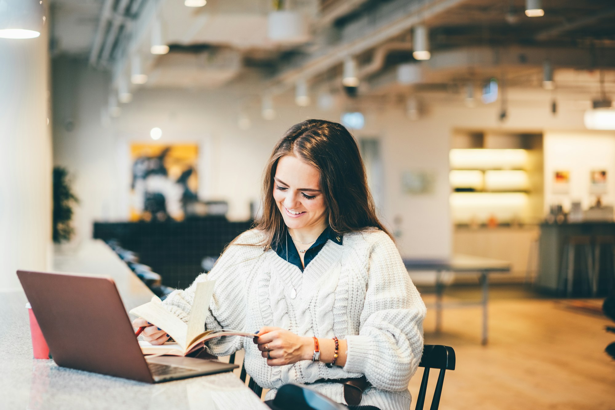 Businesswoman working on laptop in modern coworking.