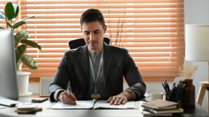 Handsome businessman in suit working with computer at modern office.