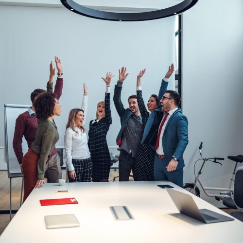 Group of coworkers cheering in an office